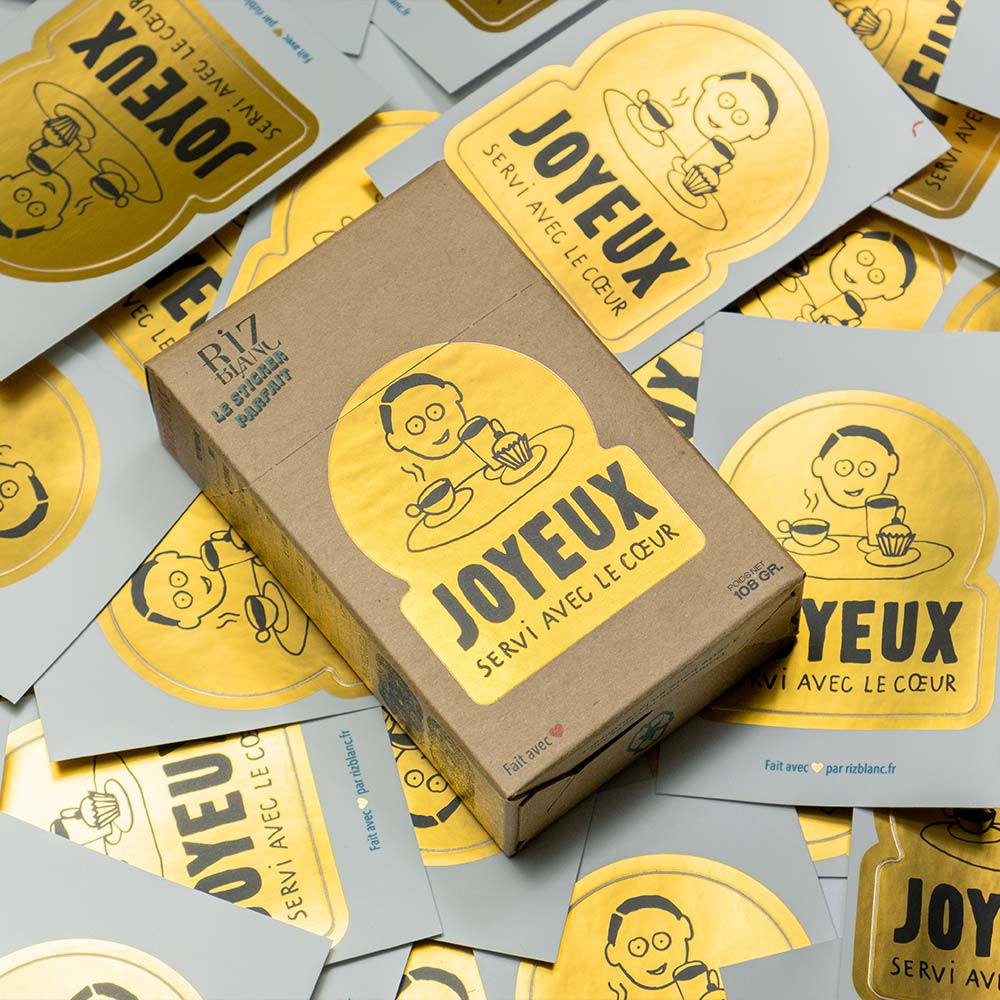 Photo d'une boîte de 'Sticker Parfait' et des stickers dorés réalisés pour un café de Montpellier.